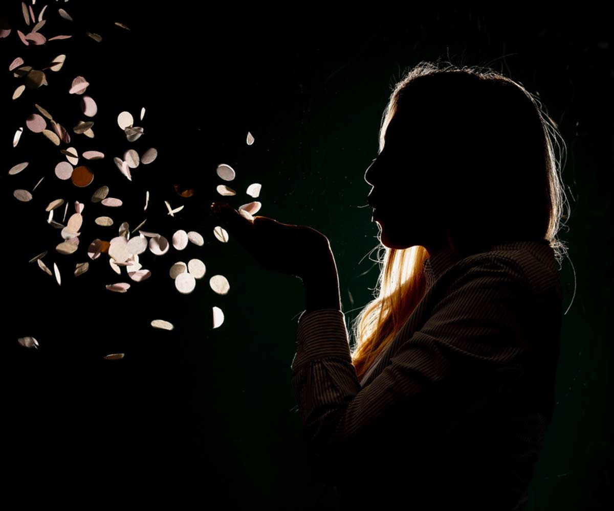 Woman blowing confetti in the dark